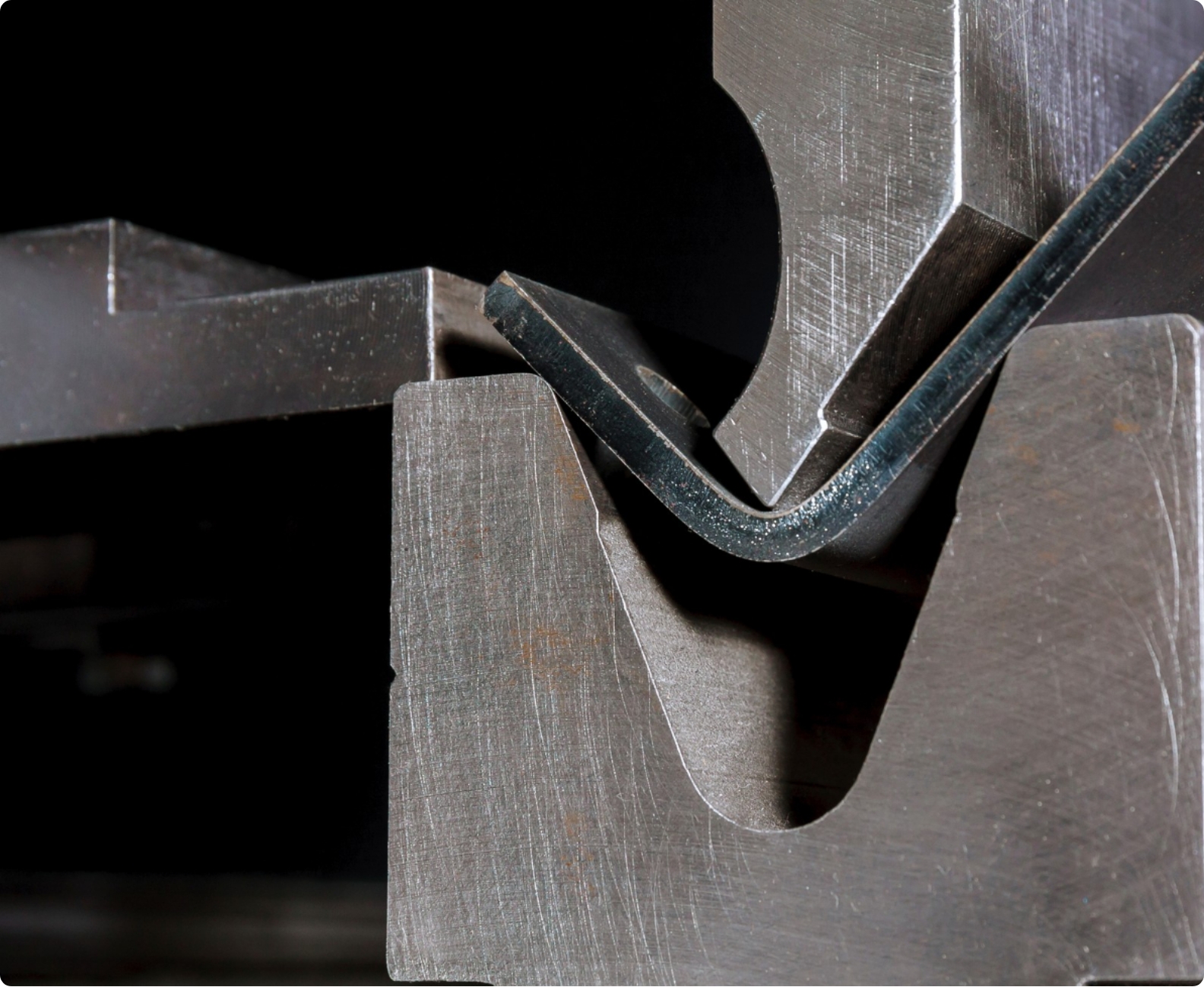 Ein Metallstück wird an einer Maschine in eine Form gebogen