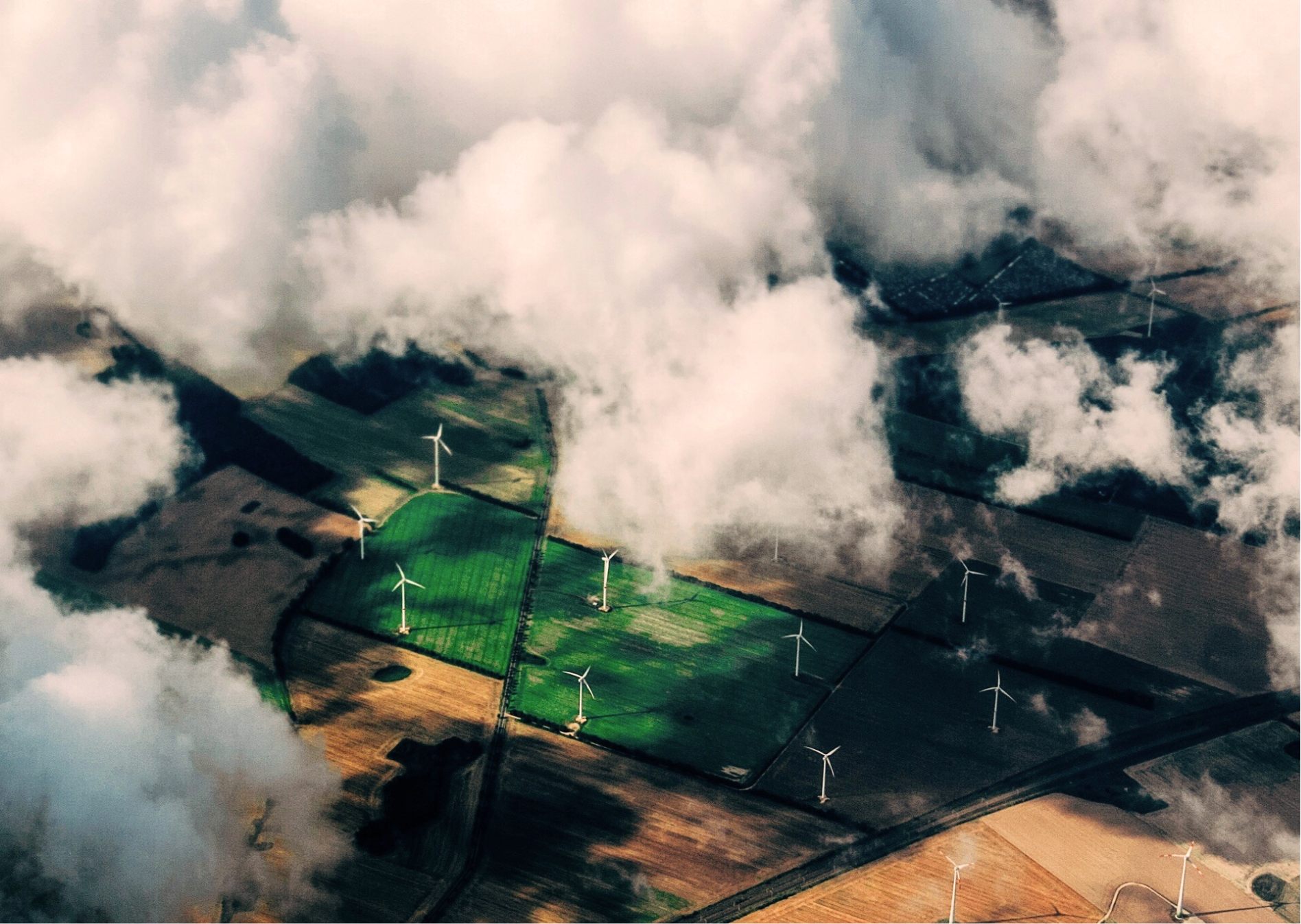 Vogelperspektive von Feldern, auf denen Windräder stehen