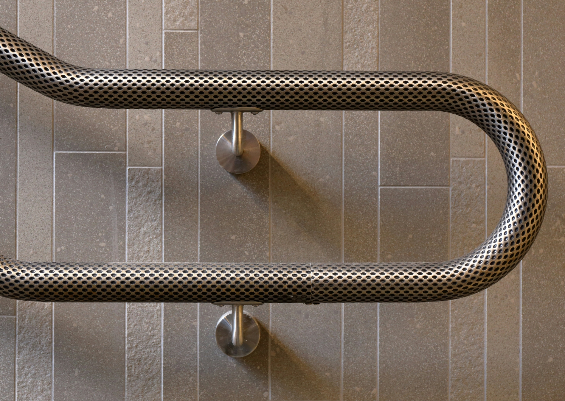 Gebogener Handlauf aus Metall mit Wabenstruktur