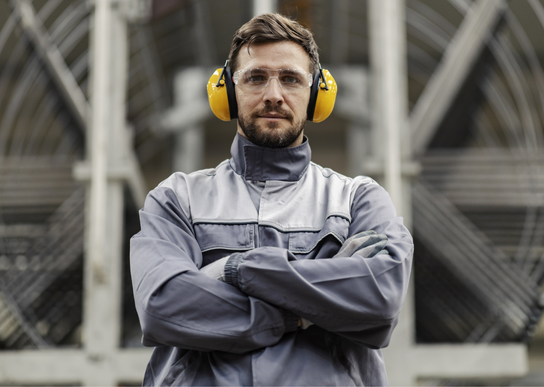 Arbeiter mit verschränkten Armen und gelbem Gehörschutz