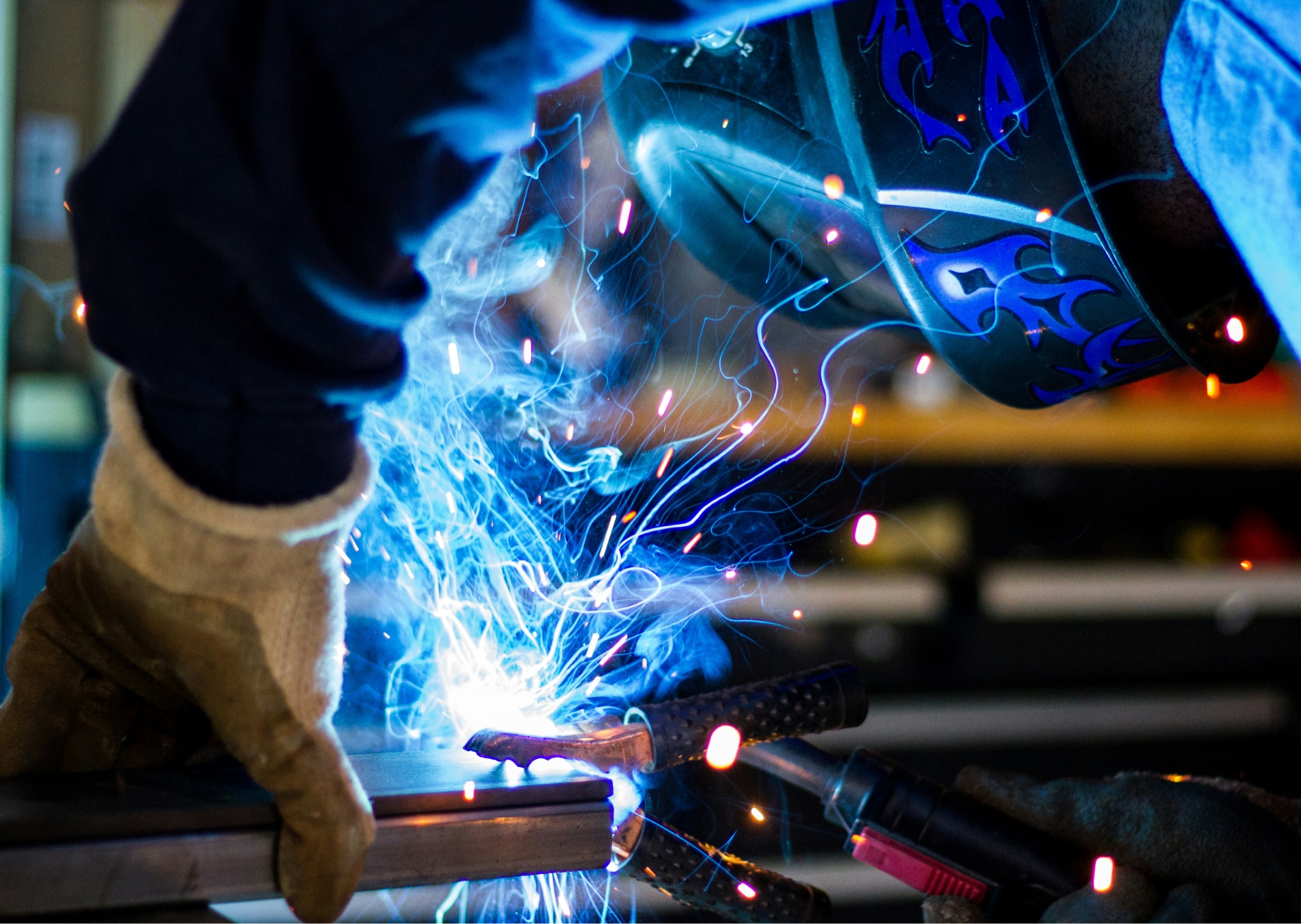 Nahaufnahme eines Arbeiters beim schweißen im blauen Lichtschein